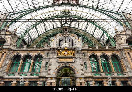 L'orologio al livello superiore della stazione ferroviaria centrale di Anversa - vista dalla piattaforma, vista simmetrica dell'orologio nella grande e ariosa sala treni. Foto Stock
