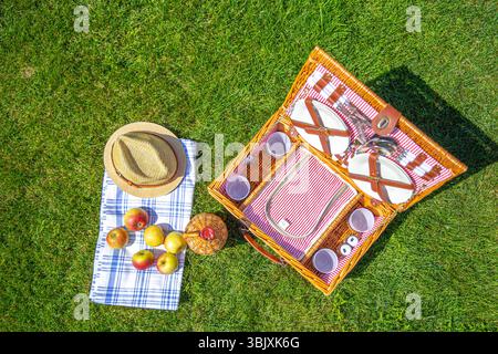 Cesto picnic sul verde prato soleggiato nel parco Foto Stock