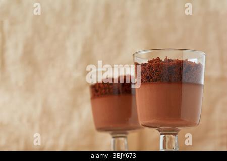 Deliziosa mousse al cioccolato da dessert con brownie in vasetti di vetro su una base di ardesia leggera, pietra o cemento. Messa a fuoco selettiva Foto Stock