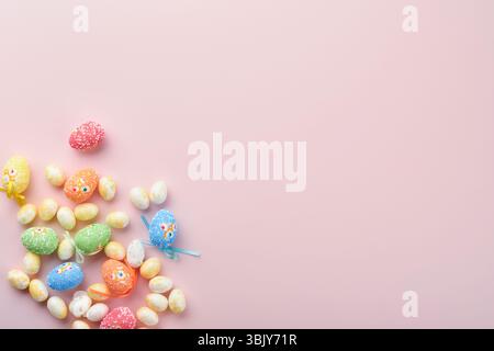 Buona Pasqua. Decorazioni con uova di Pasqua e conigli bianchi isolate su un elegante sfondo rosa pastello con rose bianche e gialle. SPR Foto Stock