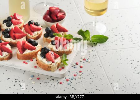 Sandwich con bandiera americana con fragole, mirtilli, panna dolce montata, formaggio morbido su pane tostato. 4 luglio American Ind Foto Stock