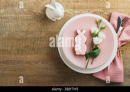 Brunch di Pasqua con tavolo. Vacanze di Pasqua di primavera con piatto bianco e rosa e tovagliolo con simboli decorativi Holiday rab Foto Stock