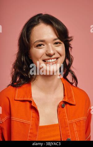 Una giovane donna elegante trasuda fiducia e gioia mentre posa in un abbigliamento alla moda. Foto Stock