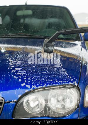 Auto lavaggio usando la spazzola speciale con sapone. Foto Stock