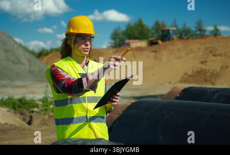 Il numero di tubi sul cantiere è contato da un appaltatore. Foto Stock