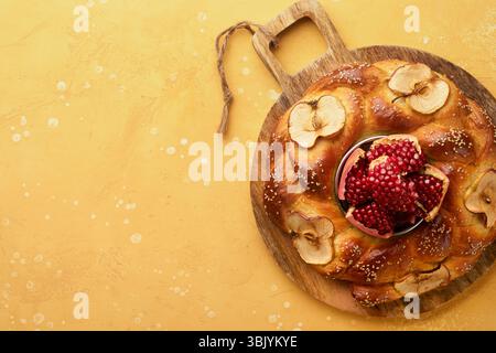 Vacanze ebraiche - Rosh Hashanah o Rosh Hashana. Melograno, mele, miele e sfide rotonde su sfondo rustico giallo. Foto Stock