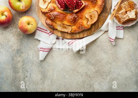 Vacanze ebraiche - Rosh Hashanah o Rosh Hashana. Melograno, mele, miele e sfide rotonde su sfondo rustico grigio. J Foto Stock