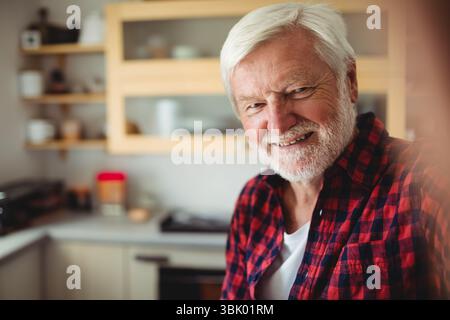 Armadietti da cucina in legno con porte in vetro e ripiani che contengono piatti, vasetti sopra il piano di lavoro Foto Stock