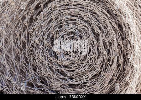 Rete a rete in acciaio, intrecciata in un rotolo, primo piano. Foto Stock