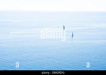 Due barche a vela sul mare blu calmo sotto il cielo limpido Foto Stock