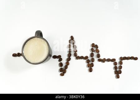 I chicchi di caffè sono disposti a forma di linea del battito cardiaco accanto a una tazza di caffè, a simboleggiare l'effetto rinvigorente della caffeina Foto Stock