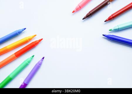 Una collezione di penne colorate con punta in feltro disposte in un motivo circolare intorno a un centro bianco vuoto Foto Stock