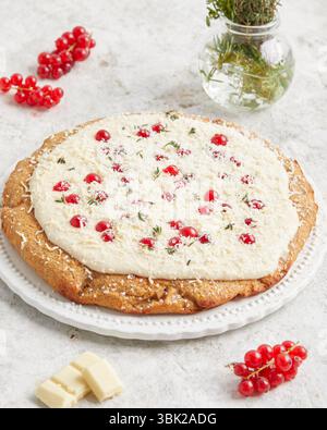 Torta al limone con grano intero condita con salsa al cioccolato bianco e ribes rosso: Un dessert stagionale, perfetto per il brunch, l'ora del caffè o per le celebre estive Foto Stock