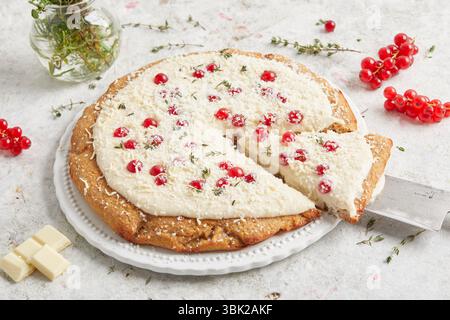 Torta al limone con grano intero condita con salsa al cioccolato bianco e ribes rosso: Un dessert stagionale, perfetto per il brunch, l'ora del caffè o per le celebre estive Foto Stock
