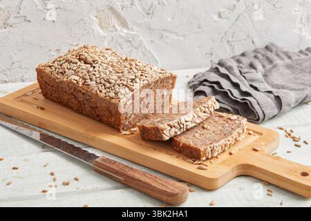 Pane rustico di segale su un asse di legno: Tradizionale pane integrale, perfetto per colazione, cibo e scene di cottura Foto Stock