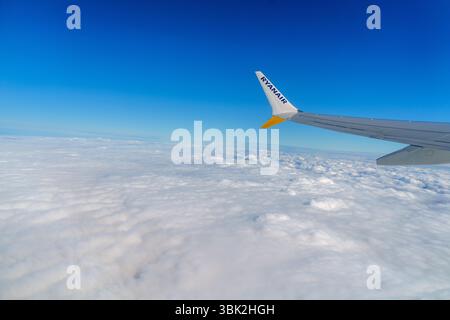 Tallinn, Estonia, 30.03.2024 - l'ala dell'aeroplano vola sopra le soffici nuvole, con una vista panoramica del volo. Foto Stock