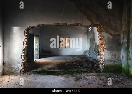 Edificio danneggiato interno con grande foro nella parete Foto Stock