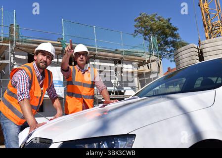 Il lavoro di squadra sul sito in costruzione - site manager e architetto sul sito durante la costruzione di una casa Foto Stock
