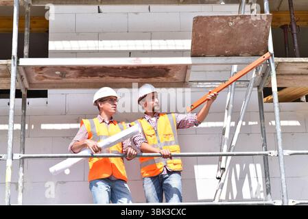 Costruzione di manager e architetto sul sito durante la costruzione di una casa - la pianificazione e il controllo sul sito - il lavoro di squadra Foto Stock