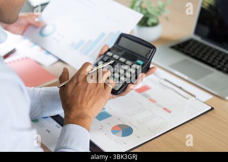 Gestione finanziaria e analisi. Uso professionale della calcolatrice per i calcoli finanziari in ufficio. Foto Stock
