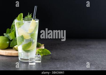 Cocktail classico Mojito con lime e menta su sfondo ardesia nera Foto Stock
