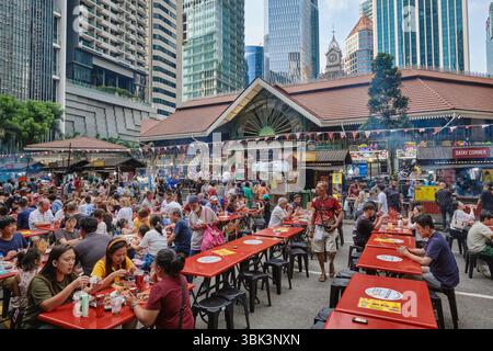 Una folla di clienti che mangiano fuori nella cosiddetta Satay Street fuori dal Lau Pa Sat Hawker Center, Raffles Place, Singapore, Sud-est asiatico Foto Stock