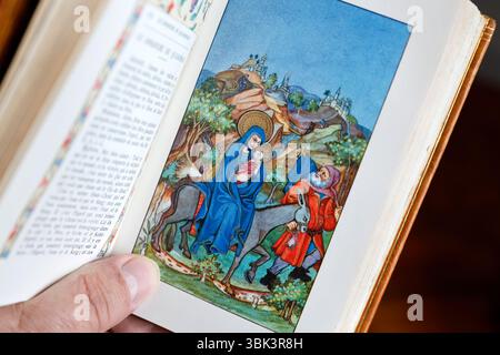 Uomo cattolico che legge un messale illustrato. Foto Stock