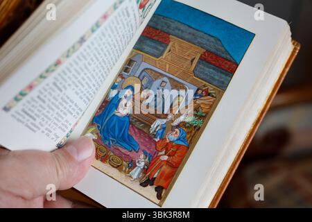 Uomo cattolico che legge un messale illustrato. Natività di Gesù o nascita di Cristo. L'Adorazione dei Pastori. Foto Stock