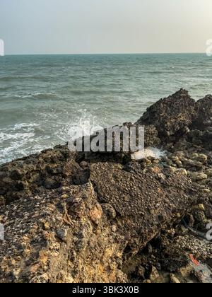La mattina presto alla spiaggia di Jaffna, con mare calmo e piccole onde che si infrangono. Foto Stock