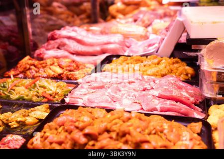 Diversi tipi di carne e verdura marinate in mostra al supermercato Foto Stock