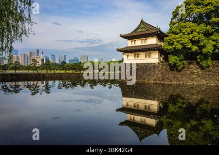 Il fossato di Kikyo-bori intorno al vecchio castello di Edo con la torre di guardia Sakurada Tatsumi Yagura e i moderni grattacieli della città di Tokyo sullo sfondo. Foto Stock
