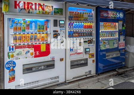 Fila di distributori automatici a Tokyo, Giappone. Il Giappone ha una delle più alte densità di distributori automatici al mondo. Foto Stock