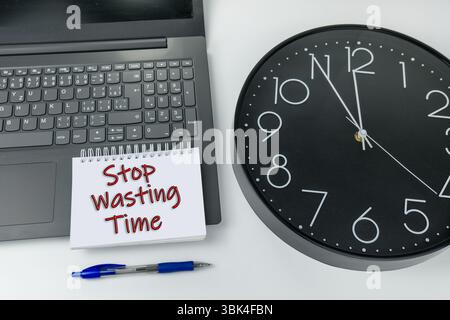 Basta perdere tempo scritto sul laptop con l'orologio Foto Stock