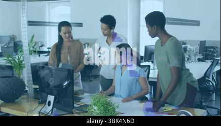 Revisione di quattro donne in abbigliamento da lavoro, analisi di progetti alla scrivania, con impianto di monitoraggio Foto Stock