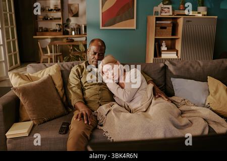 Donna caucasica anziana che riposa la testa sull'uomo Nero anziano abbracciando affettuosamente Foto Stock