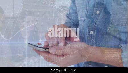Toccando lo schermo dello smartphone nella camicia in denim, visualizzando i dati in ufficio, con sovrapposizioni di laptop e carte Foto Stock