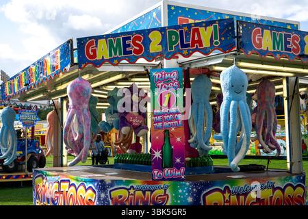 Uno stand fieristico a Saffron Walden, Essex, Regno Unito, con un gioco Ring Toss e peluche di polpo in palio. Foto Stock
