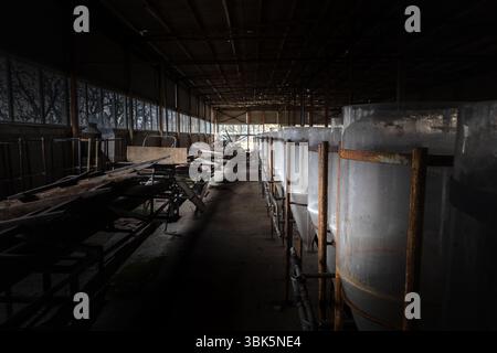Industriali abbandonati interno con vasche di allevamento di angolazione Foto Stock
