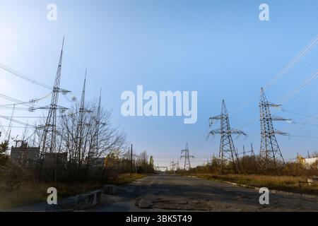 Grandi piloni a potenza stazione di distribuzione sotto il cielo blu Foto Stock