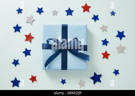 Confezione regalo blu e stelle rosse, bianche e blu su sfondo blu. Biglietto d'auguri. Vista dall'alto. Posizione piatta. Giorno dell'indipendenza americana. Buon Labor Day Foto Stock