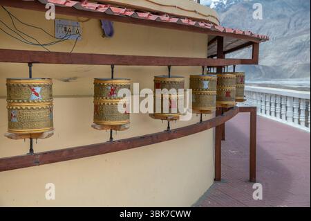 Ruote di preghiera buddista vicino alla statua del Buddha Maitreya al monastero di Diskit, Nubra Valley, Ladakh, India Foto Stock