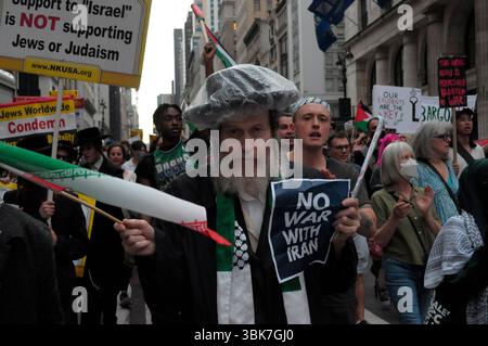 I membri di Neturei Karta che sono ebrei ultra-ortodossi e anti-sionisti detengono la bandiera e i cartelli iraniani durante una marcia di protesta contro l'Iran. I manifestanti si sono radunati a Manhattan opponendosi agli attacchi aerei delle forze di difesa israeliane contro l'Iran. I manifestanti hanno anche condannato la possibilità che gli Stati Uniti si unissero a Israele nella guerra contro l'Iran. Inoltre, i manifestanti hanno criticato le operazioni militari dell'IDF a Gaza. Il raduno si è verificato mentre Israele e Iran hanno scambiato attacchi missilistici l'uno contro l'altro negli ultimi sei giorni. Secondo i funzionari americani, l'Iran si sta preparando ad attaccare gli Stati Uniti Foto Stock