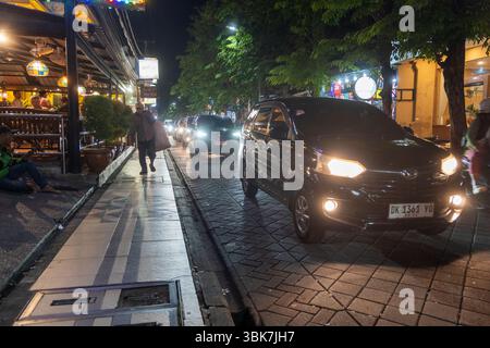 Bali, Indonesia - 25 dicembre 2024: Strada trafficata con molte auto. La strada è illuminata di notte Foto Stock