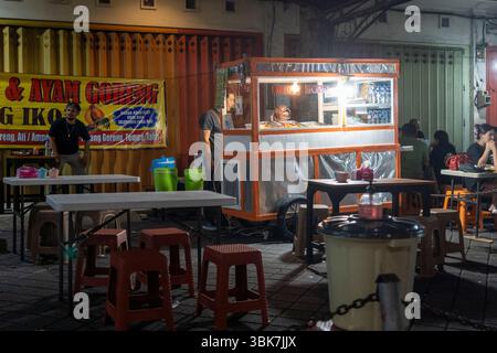 Bali, Indonesia - 25 dicembre 2024: Piccolo chiosco di cibo che vende anatra fritta di notte Foto Stock