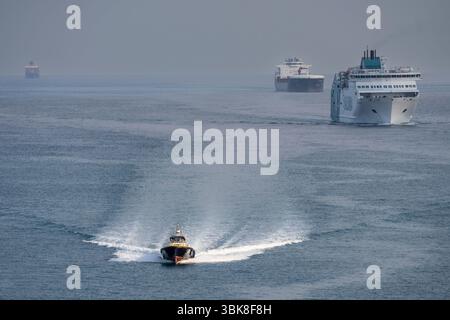 Pilota di porto che naviga di fronte alle navi che accedono al porto di Barcellona, ​​Catalonia, Spagna Foto Stock