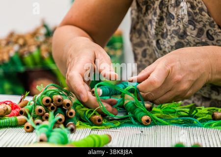 Primo piano: Un tessitore alla Cité internationale de la tapisserie di Aubusson lavora su un motivo dell'artista giapponese Hayao Miyazaki, "mio vicino Totoro". Il motivo è costituito da 200 tonalità di verde. Il tappeto alla fine misurerà 31 metri quadrati. Rue Williams Dumazet, Aubusson, Nouvelle-Aquitaine, Francia Foto Stock