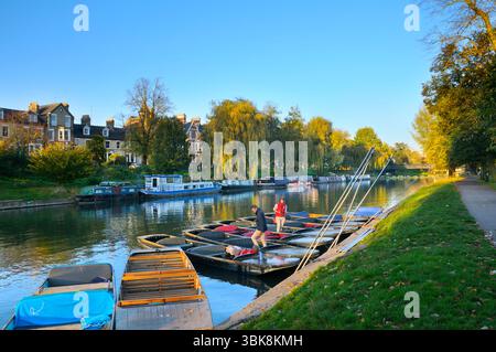 Tre uomini cacciatori di barche o autisti si rilassano in barca o in punt nel tardo pomeriggio sul River Cam vicino a Jesus Green e Jesus Lock, Cambridge, Inghilterra, Regno Unito Foto Stock