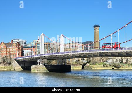 Vista del Chelsea Bridge con autobus rosso a due piani che attraversa il Tamigi da Battersea a Chelsea sulla riva nord, Londra, Inghilterra, Regno Unito. Ponti Foto Stock