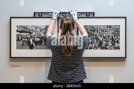 National Galleries of Scotland Modern Two, Edimburgo, Scozia, Regno Unito, 19 giugno 2025, nuova mostra Resistance: anteprima stampa della mostra ideata dall'artista e regista Steve McQueen. Esplora come gli atti di resistenza hanno plasmato la vita nel Regno Unito e il potente ruolo della fotografia che documenta e guida il cambiamento con circa 200 fotografie di un secolo di attivismo. Nella foto: Il personale prepara le fotografie per l'apertura. Crediti: Sally Anderson/Alamy Live News Foto Stock