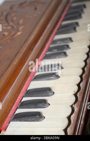 Un tradizionale armonium antico, uno strumento musicale, ha i tasti color avorio e neri disposti in un familiare schema di tastiera. Foto Stock